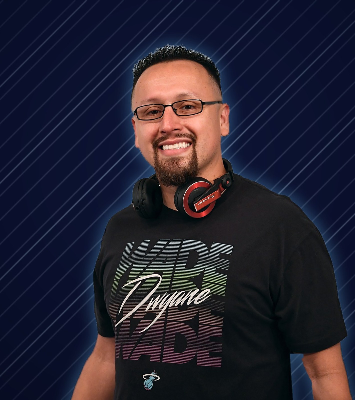 DJ LS (Juan Zafra) smiling on a navy and chrome background